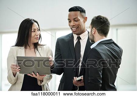 Business people standing and discussing in the hotel lobby View Large Photo Image Stock Image - Business people standing and discussing in the hotel lobby. Fotosearch