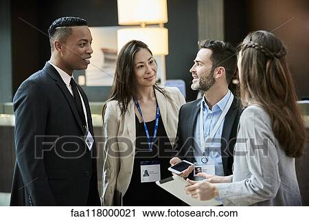 Business people standing and discussing in the hotel lobby View Large Photo Image Stock Image - Business people standing and discussing in the hotel lobby. Fotosearch