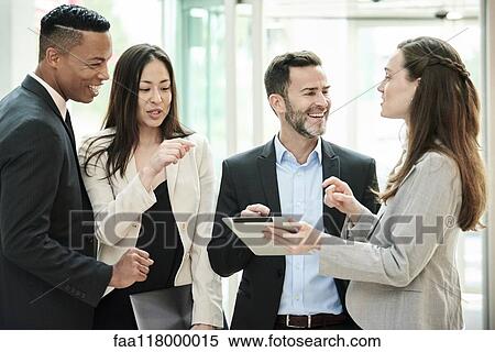 Business people standing and discussing in the hotel lobby View Large Photo Image Stock Photography - Business people standing and discussing in the hotel lobby. Fotosearch