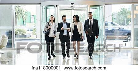 Business people talking while entering in hotel lobby View Large Photo Image Stock Image - Business people talking while entering in hotel lobby. Fotosearch