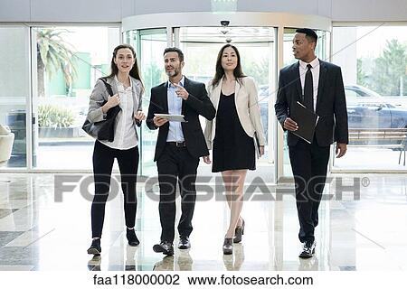 Business people talking while entering in hotel lobby View Large Photo Image Stock Image - Business people talking while entering in hotel lobby. Fotosearch