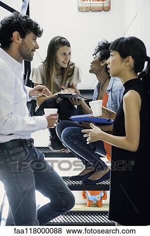 Business people talking with each other in office View Large Photo Image Stock Photo - Business people talking with each other in office. Fotosearch