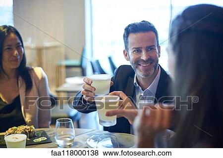 Stock Photo - Business people toasting drink at bar. Fotosearch