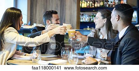 Stock Image - Business people toasting drink in bar. Fotosearch
