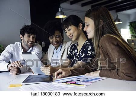 Stock Photo - Business people using digital tablet in office. Fotosearch
