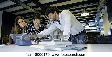 Business people using laptop in office View Large Photo Image Stock Image - Business people using laptop in office. Fotosearch