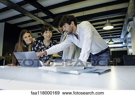 Stock Photo - Business people using laptop in office. Fotosearch