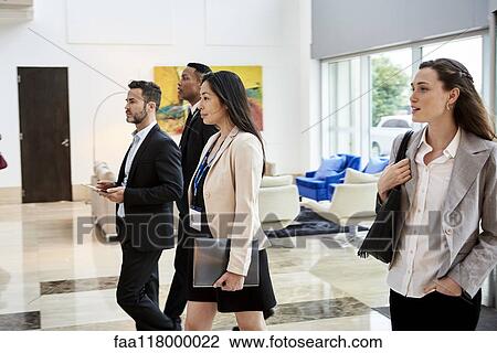 Business people walking in hotel lobby View Large Photo Image Stock Image - Business people walking in hotel lobby. Fotosearch
