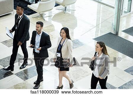 Business people walking in hotel lobby View Large Photo Image Stock Photo - Business people walking in hotel lobby. Fotosearch