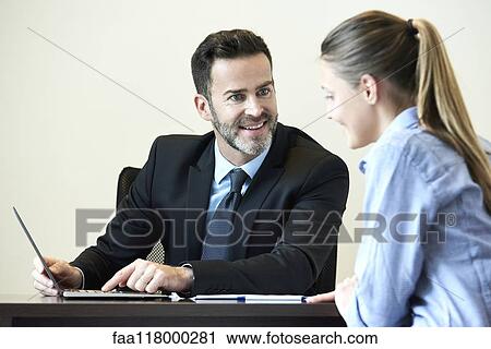 Businessman and businesswoman having meeting in office View Large Photo Image Stock Image - Businessman and businesswoman having meeting in office. Fotosearch