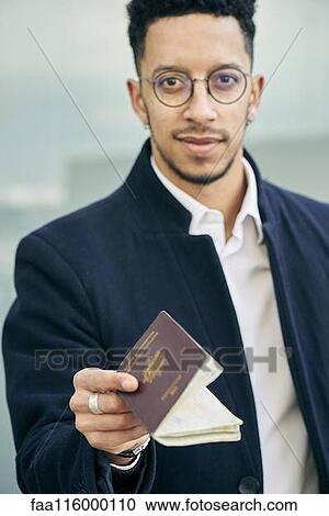 Stock Image - Businessman holding passport. Fotosearch