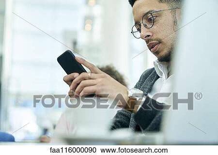 Stock Image - Businessman holding smartphone. Fotosearch