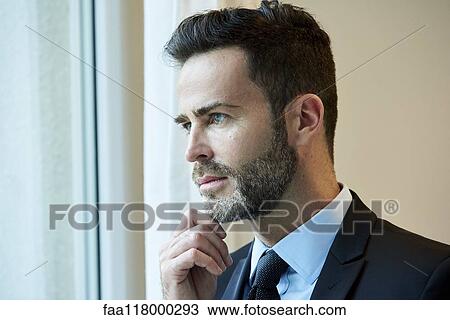 Businessman looking through office window View Large Photo Image Stock Image - Businessman looking through office window. Fotosearch