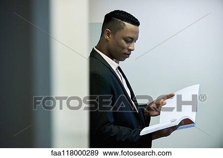 Businessman reading documents in hotel lobby View Large Photo Image Stock Photo - Businessman reading documents in hotel lobby. Fotosearch