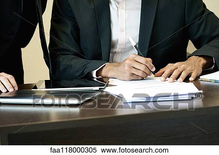 Businessman signing a document in office View Large Photo Image Stock Photography - Businessman signing a document in office. Fotosearch