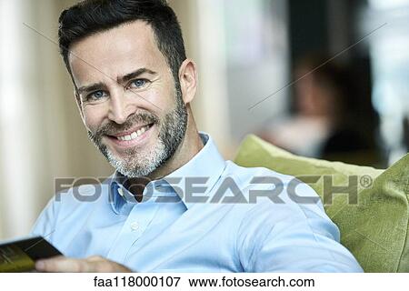 Stock Photo - Businessman sitting in hotel lobby. Fotosearch