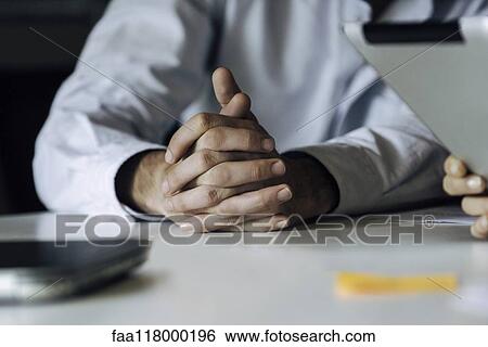Businessman sitting in office View Large Photo Image Stock Photograph - Businessman sitting in office. Fotosearch