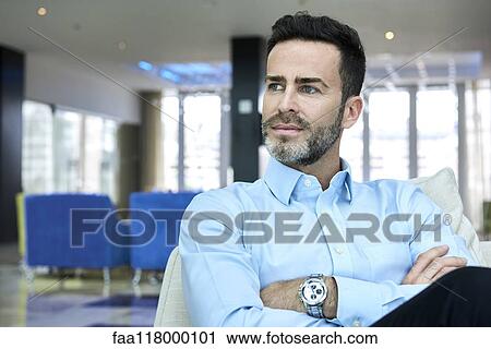 Businessman sitting on sofa with arms crossed View Large Photo Image Stock Image - Businessman sitting on sofa with arms crossed. Fotosearch