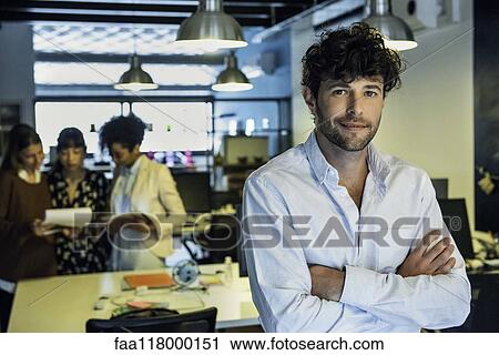 Stock Image - Businessman standing in office. Fotosearch
