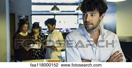 Businessman standing in office View Large Photo Image Stock Image - Businessman standing in office. Fotosearch