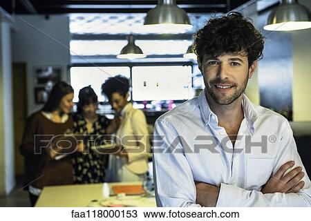 Stock Image - Businessman standing in office. Fotosearch