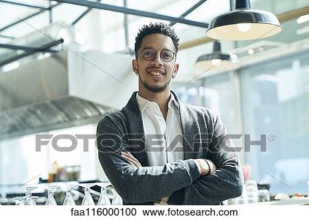 Stock Image - Businessman standing in restaurant. Fotosearch
