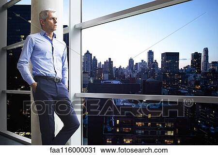 Businessman standing near window View Large Photo Image Stock Image - Businessman standing near window. Fotosearch