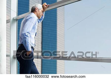 Businessman standing near window View Large Photo Image Stock Image - Businessman standing near window. Fotosearch
