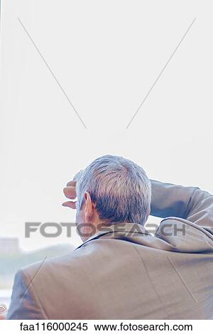 Businessman standing near window View Large Photo Image Stock Photography - Businessman standing near window. Fotosearch