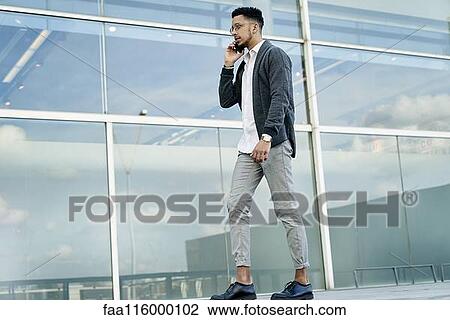Stock Image - Businessman talking on smartphone. Fotosearch