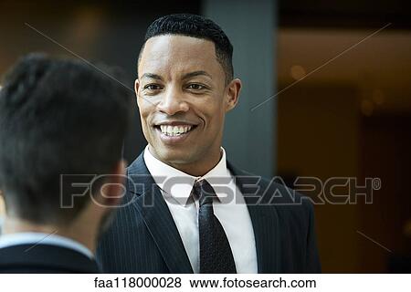 Businessman talking with his colleague in hotel View Large Photo Image Stock Photo - Businessman talking with his colleague in hotel. Fotosearch