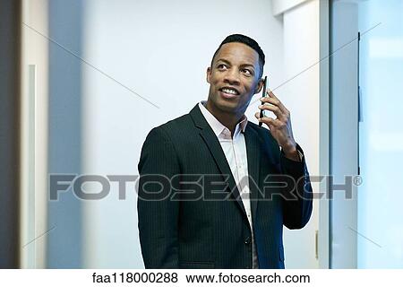 Businessman using smart phone in hotel lobby View Large Photo Image Stock Photo - Businessman using smart phone in hotel lobby. Fotosearch