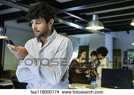 Picture - Businessman using smartphone. Fotosearch