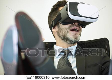 Businessman using virtual reality headset in office View Large Photo Image Stock Image - Businessman using virtual reality headset in office. Fotosearch