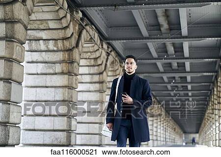 Stock Image - Businessman walking outdoors. Fotosearch