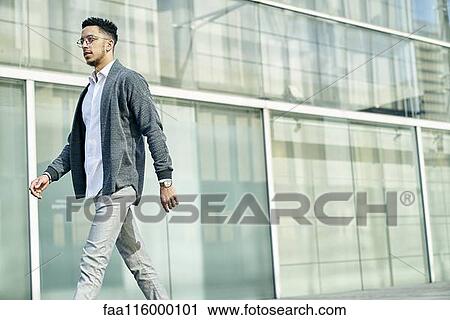 Businessman walking outside office View Large Photo Image Stock Image - Businessman walking outside office. Fotosearch