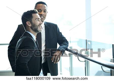 Businessmen looking outside the hotel window View Large Photo Image Stock Photo - Businessmen looking outside the hotel window. Fotosearch