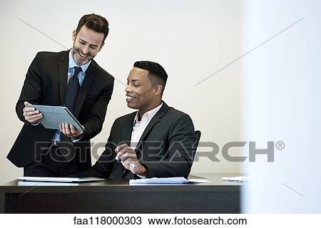 Businessmen using a digital tablet in office View Large Photo Image Stock Image - Businessmen using a digital tablet in office. Fotosearch