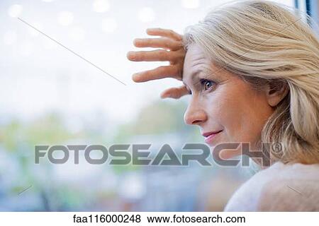 Businesswoman standing near window View Large Photo Image Stock Photo - Businesswoman standing near window. Fotosearch