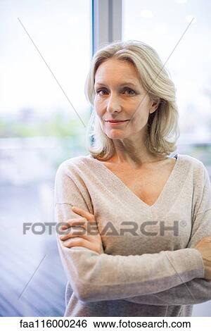 Businesswoman standing near window View Large Photo Image Stock Photograph - Businesswoman standing near window. Fotosearch