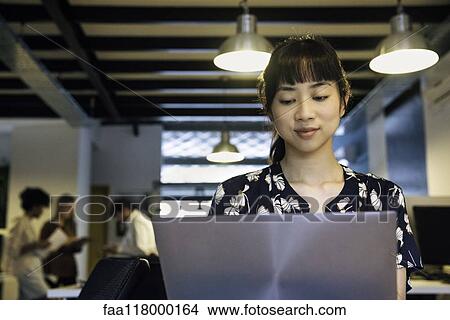Picture - Businesswoman using laptop. Fotosearch