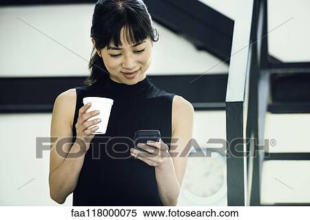 Stock Photography - Businesswoman using smartphone. Fotosearch
