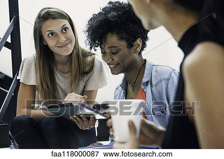 Businesswomen using digital tablet in office View Large Photo Image Stock Photo - Businesswomen using digital tablet in office. Fotosearch