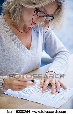 Close-up of businesswoman reading document View Large Photo Image Picture - Close-up of businesswoman reading document. Fotosearch