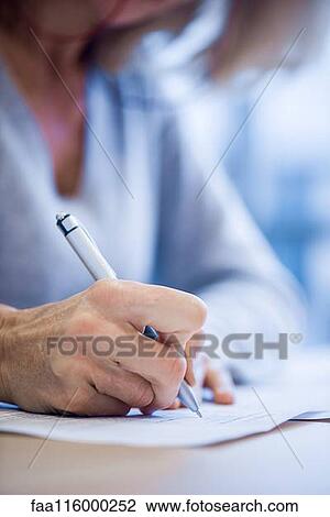 Stock Image - Close-up of businesswoman signing document. Fotosearch