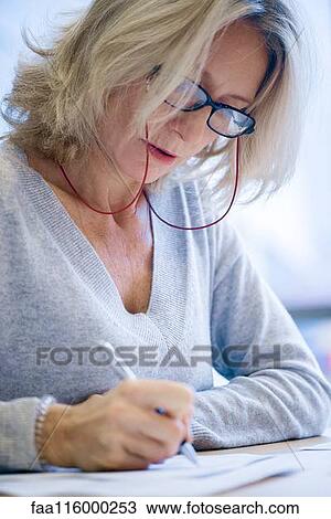 Stock Image - Close-up of businesswoman signing document. Fotosearch