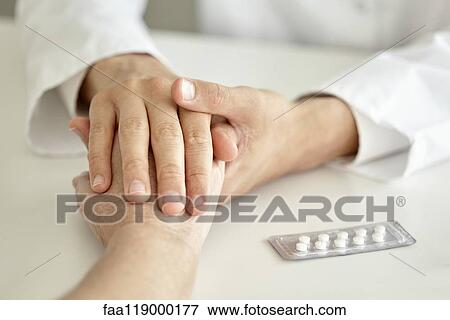 Close-up of doctor holding patient's hand View Large Photo Image Stock Photo - Close-up of doctor holding patient's hand. Fotosearch