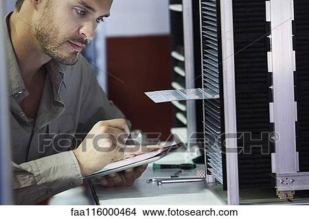 Close-up of engineer looking at chip in office View Large Photo Image Picture - Close-up of engineer looking at chip in office. Fotosearch
