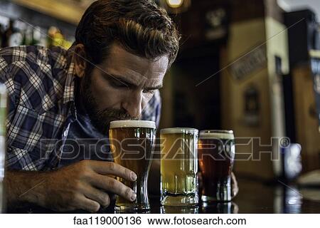 Close-up of man smelling beer View Large Photo Image Stock Photograph - Close-up of man smelling beer. Fotosearch