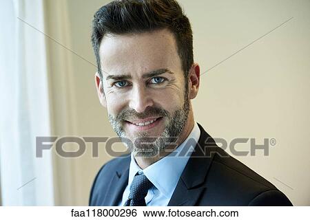 Close-up of smiling businessman standing in hotel View Large Photo Image Stock Photograph - Close-up of smiling businessman standing in hotel. Fotosearch